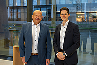 Zwei Männer stehen im Foyer eines Gebäudes